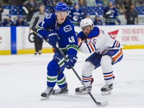 Vancouver Canucks prospect Olli Juolevi (left), the club’s top pick in the 2016 NHL Entry Draft at fifth overall, passes the puck before getting checked by Edmonton Oiler Joe Gambardella during a Young Stars Classic game at Penticton’s South Okanagan Events Centre in September 2017.