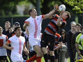 St. George's Saints, in white, complete hard against Lord Byng at the B.C. boys sevens rugby championship final at UBC's Wolfson Field on April 27, 2014.