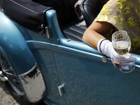 A woman holds a glass of Champagne while sitting in a Delahaye 135M at Concorso d'Eleganza Villa d'Este. The 1938 Delahaye 135M was known as the prototype for the many elegant French luxury tourers that came after WWII. It has an inline-six engine and a top output of 115 horsepower. It is owned by Emma Beanland of Monaco.