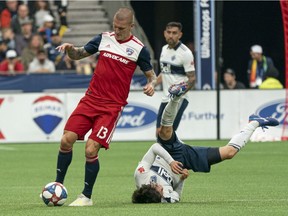 Vancouver Whitecaps' Hwang In-Beom, right, gets fouled by FC Dallas' Zdenek Ondrasek during the second half of an MLS soccer game in Vancouver, on Saturday May 25, 2019.