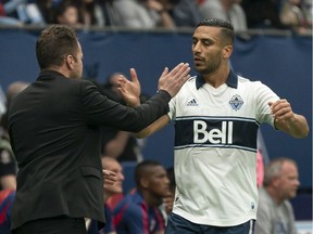 Vancouver Whitecaps' Ali Adnan (right) celebrates with head coach Marc Dos Santos after scoring a goal against Dallas FC during the first half of an MLS soccer game in Vancouver on Saturday, May 25, 2019.