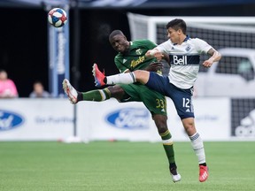 Portland Timbers' Larrys Mabiala and Vancouver Whitecaps' Fredy Montero, right battle for the ball during the first half of Friday's MLS game in Vancouver.