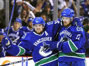 Daniel and Henrik Sedin celebrate after Daniel scored against the Chicago Blackhawks during the first period in Game Four of the Western Conference Semifinals during the 2010 NHL Stanley Cup Playoffs