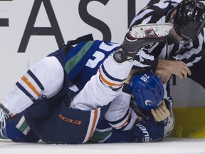 Vancouver Canucks Antoine Roussel's stick gets between the legs of New York Islanders' Cal Clutterback in the first period of a regular season NHL hockey game at Rogers Arena on February 23, 2019. Photo: Gerry Kahrmann/Postmedia