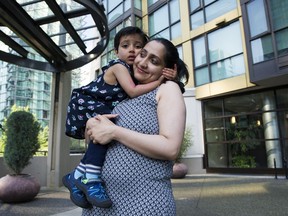 Kartiki Desphande and her daughter Nova play in front of their building in Vancouver. The family fears they will be forced to leave the city if they cannot find childcare.