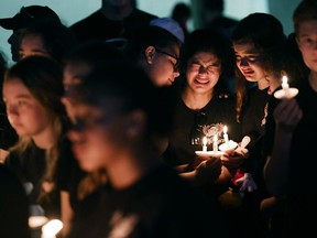 Marianna Guttierez, 14, center right, and other students of Marjory Stoneman Douglas High School gather with others for a candlelight vigil in honor of the victims of the school shooting on Feb. 15, 2018, in Parkland, Fla. 17 people were killed in the mass shooting.