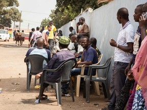 A group of men sit and read newspapers at a social spot in Accra, Ghana on January 17, 2019.