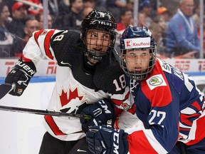 Canada's Peyton Krebs (18) battles against Slovakia's Samuel Knazko (22) during first period Hlinka Gretzky Cup action in Edmonton on Tuesday, August 7, 2018. Photo: Codie McLachlan/CP