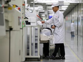 An employee works on the production line of Huawei P30 smartphone at its Songshan Lake Manufacturing Centre in Dongguan, China.