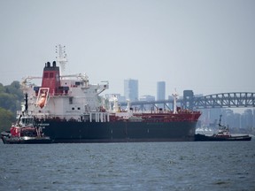 Tug boats prepare a oil tanker to go under the Second Narrows bridge in Burrard Inlet, just outside of metro Vancouver, B.C., Tuesday, May, 1, 2018.