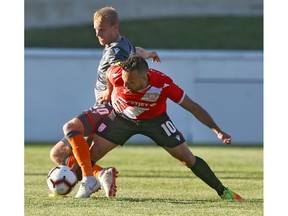 Forge FC's Kyle Bekker (L) is challenged by Cavalry FC counterpart Sergio Camargo during CPL Action at ATCO Field at Spruce Meadows on Tuesday night. Photo by Jim Wells/Postmedia.