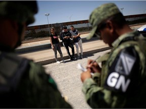 FILE PHOTO: Members of Mexico's National Guard detain Cuban migrants after they were trying to cross illegally the border between the U.S. and Mexico, in Ciudad Juarez, Mexico June 21, 2019. REUTERS/Jose Luis Gonzalez/File Photo