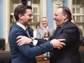 Quebec Minister of Immigration, Diversity and Inclusiveness Simon Jolin Barrette, left, is congratulated by Quebec Premier Francois Legault after they voted a legislation on secularism.