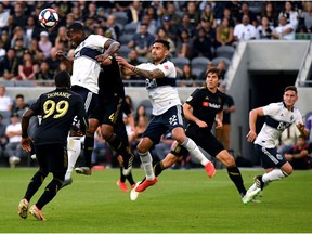 Doneil Henry #2 of Vancouver Whitecaps clears a corner kick in front of Eddie Segura #4 of Los Angeles FC during the first half at Banc of California Stadium on July 06, 2019 in Los Angeles, California.