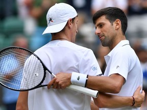 Serbia's Novak Djokovic (right) shakes hands with France's Ugo Humbert after Djokovic won their men's singles fourth-round match at the 2019 Wimbledon Championships at The All England Lawn Tennis Club in Wimbledon, southwest London, on July 8, 2019.