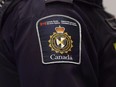 A Canadian Border Services agent stands watch at Pearson International Airport in Toronto on Tuesday, December 8, 2015. The Canada Border Services Agency will soon force all border security officers working with detained migrants to wear defensive gear, including batons, pepper spray and bulletproof vests, a policy that's drawing widespread concern over a perceived "criminalization" of asylum seekers.