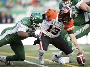 Saskatchewan Roughriders defensive lineman Charleston Hughes, left, knocks the ball loose from B.C. Lions quarterback Mike Reilly during the July 20 CFL tilt at Mosaic Stadium in Regina.