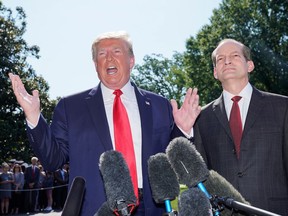U.S. President Donald Trump announces the resignation of Labor Secretary Alex Acosta (right)  on the South Lawn of the White House in Washington on July 12, 2019.
