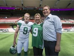 Andrew Scheer, leader of the Conservative Party of Canada and MP for the Regina-Qu'Appelle riding, with wife Jill and brother-in-law Jon Ryan, a punter with the Saskatchewan Roughriders. All three huddled for photos before the B.C. Lions-Roughriders game at B.C. Place Stadium on Saturday.