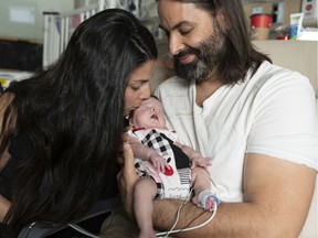 Two month old premature baby girl Beatrice May Benskin is kissed by her mother Stephanie while dad Jeremiah looks on in the NICU at Children's Hospital in Vancouver.