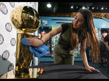 Tenneya Martin of the Toronto Raptors gives the Larry O'Brien NBA Championship Trophy a quick polish before the public gets to see it at the B.C. Sports Hall of Fame in Vancouver on Tuesday, July 23.