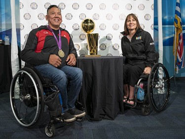 Paralympian Richard Peter (left) and Marnie Abbott pose for a photo with the Larry O'Brien NBA Championship Trophy at the B.C. Sports Hall of Fame in Vancouver on Tuesday, July 23.