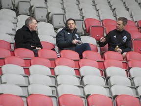 Whitecaps team president Bob Lenarduzzi, left, talks with vice-president Greg Anderson and a staff member at B.C. Place.