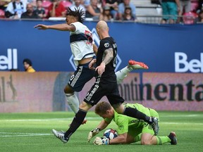 Vancouver Whitecaps forward Theo Bair (50) jumps over Sporting Kansas City goalkeeper Tim Melia (29) while making a save during the first half at BC Place.