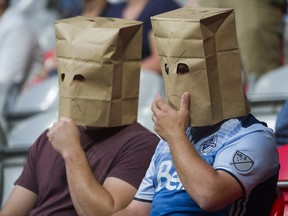 Vancouver Whitecaps fans wear paper bags on their heads as they sit in the stands watching their team lost 3-1 to the San Jose Earthquakes in a regular season MLS soccer game at BC Place on Saturday.