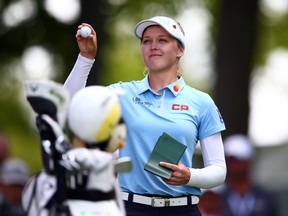 Brooke Henderson of Canada shows her ball prior to teeing off on the 1st hole during the third round of the CP Women's Open at Magna Golf Club on Saturday.