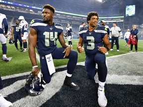 Seattle Seahawks receiver D.K. Metcalf (left) and quarterback Russell Wilson each take a knee after an NFL pre-season win over the Denver Broncos at Seattle’s CenturyLink Field on Aug. 8, 2019.