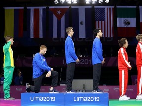Gold medalist Race Imboden of United States  takes a knee during the National Anthem Ceremony in the podium of Fencing Men's Foil Team Gold Medal Match Match on Day 14 of Lima 2019 Pan American Games at Fencing Pavilion of Lima Convention Center on August 09, 2019 in Lima, Peru.