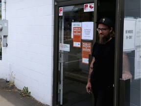 Employee Myko Hodgson stands at the door of the Trees of Eden dispensary on Alpha street to turn away potential customers after the shop was closed on Wednesday. Photo: Adrian Lam/Victoria Times Colonist