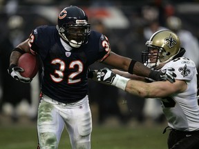 Cedric Benson #32 of the Chicago Bears stiff arms Mark Simoneau #53 of the New Orleans Saints during the NFC Championship Game in 2007. TMZ is reporting that Benson was killed in a crash Sunday morning that Saturday night in Austin, Texas.