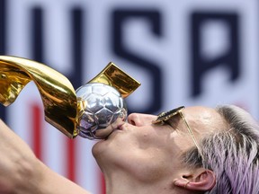 USA women's soccer player Megan Rapinoe kisses the trophy after the ticker tape parade for the women's World Cup championsin New York in July. Some 28 players took USSF to court in March alleging they were consistently paid less than their male counterparts even though their performance has been superior to the men’s team.