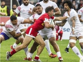 Canada's DTH van der Merwe battles past a trio of Tongans in Pacific Nations Cup rugby action at Swangard Stadium in Vancouver, B.C. on July 24, 2015.