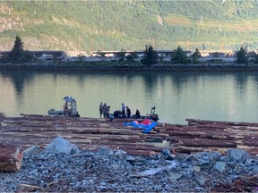 Emergency workers help a man who crash-landed onto a log boom and into the waters in front of the Stawamus Chief in Squamish on Aug. 29, 2019. The man was seriously injured.