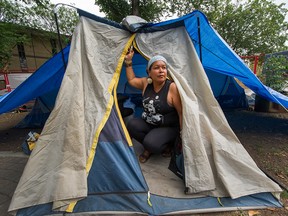 Chrissy Brett sits inside her tent as residents begin to pack up at Oppenheimer Park in Vancouver on Aug. 20.