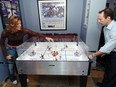 Ray Ferraro and wife Cammi Granato enjoy some table hockey in their Vancouver home. Granato's hockey school for girls will start Monday at North Shore Winter Club.