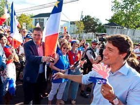 Prime Minister Justin Trudeau and Conservative Leader Andrew Scheer walk with a crowd at the Tintamarre celebration of the National Acadian Day in Dieppe, N.B., on Aug. 15, 2019.
