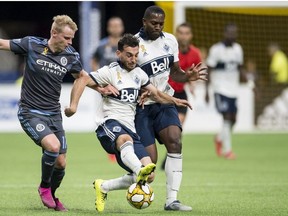 Vancouver Whitecaps midfielder Russell Teibert scrambles with New York City FC Gary Mackay-Steven during the second half of MLS soccer action.