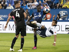 Vancouver Whitecaps forward Michaell Chirinos goes up in the air to kick the ball away from Montreal Impact defender Rudy Camacho, left, and Bacary Sagna during Major League Soccer action in Montreal on Wednesday, Aug. 28.