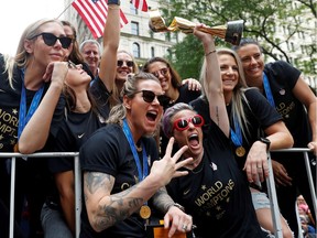 Megan Rapinoe holds up the World Cup trophy as she and her Team USA teammates celebrate winning the 2019 Women's World Cup at a champions' parade in New York.