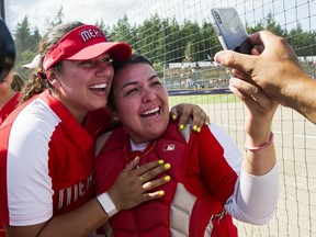 Team Mexico catcher Sashel Palacios, right, and a teammate take a selfie and then phone friends on Saturday afternoon after beating Canada 2-1 at Softball City in Surrey and  clinching a berth to the 2020 Tokyo Olympics. Canada can clinch a Summer Games berth with a win Sunday against Brazil.