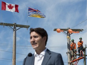 B.C. Hydro workers look on as Prime Minister Justin Trudeau makes an announcement at B.C. Hydro Trades Training Centre in Surrey on Aug. 29, 2019.