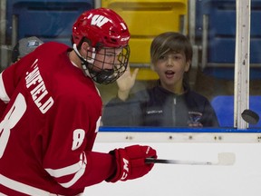 A young fan watches Wisconsin Badgers Cole Caufield bounce puck off his stick in the warm up prior to playing the UBC Thunderbirds in the first game of a two game series at UBC. The T-birds lost 3-0.