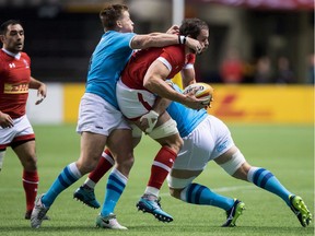 Tyler Ardron of Canada is tackled by Uruguay's Leandro Leivas, second left, and Rodrigo Capo, right, during the first half of a Rugby World Cup qualifier match in Vancouver on Jan. 27, 2018.