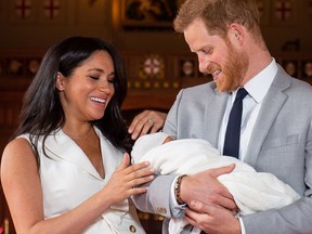 Britain's Prince Harry, Duke of Sussex (R), and his wife Meghan, Duchess of Sussex, pose for a photo with their newborn baby son, Archie Harrison Mountbatten-Windsor, in St George's Hall at Windsor Castle in Windsor, west of London on May 8, 2019.