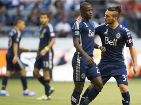 Russell Teibert of the Vancouver Whitecaps, right, is excited to play his former teammate Kekuta Manneh, left, in Cincinnati on Saturday.