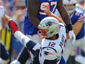 Jordan Phillips #97 of the Buffalo Bills hits Tom Brady #12 of the New England Patriots after he throws the ball during the first half at New Era Field on September 29, 2019 in Orchard Park, New York.